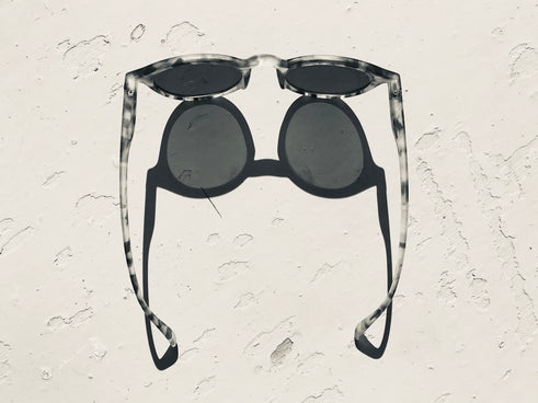 black sunglasses on white sand