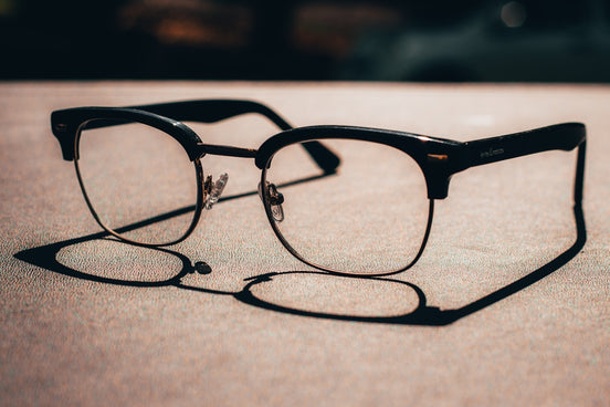 black framed eyeglasses on brown sand during daytime