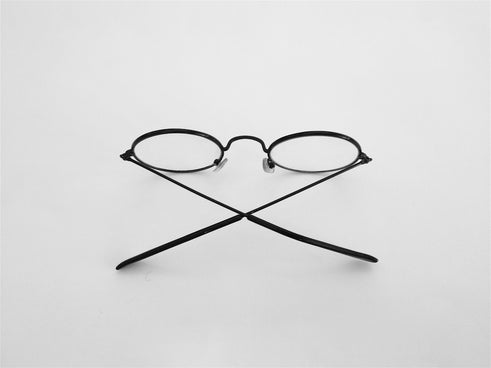 black framed eyeglasses on white surface