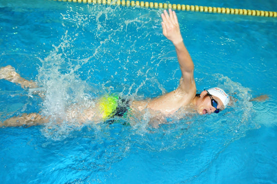 a man swimming in a pool with a ball