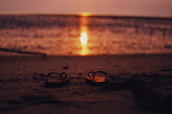 a pair of sunglasses sitting on top of a sandy beach