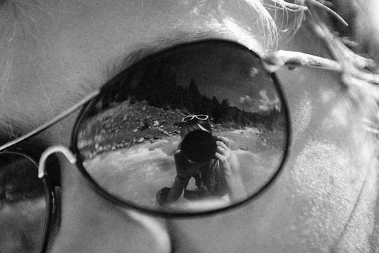 a woman's reflection in a pair of glasses