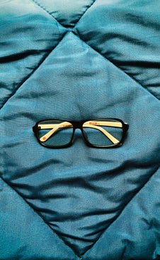 a pair of glasses on a bed