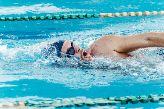 a man swimming in a pool wearing a swimming cap