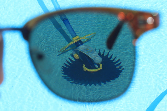 the reflection of a pair of sunglasses in a pool