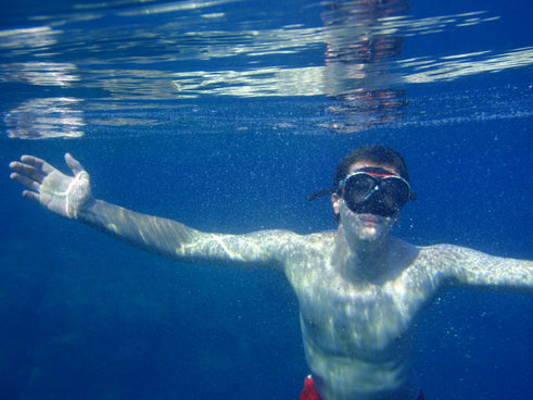 a man swimming in the water with his arms outstretched
