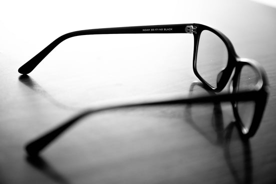 A pair of glasses sitting on top of a wooden table