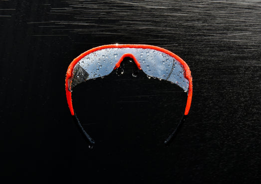 A pair of ski goggles sitting on top of a black surface